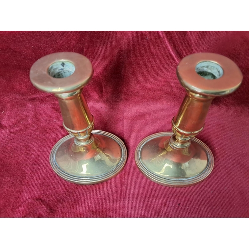 60 - A pair of vintage brass candlesticks, each measuring approx. 15cm tall.