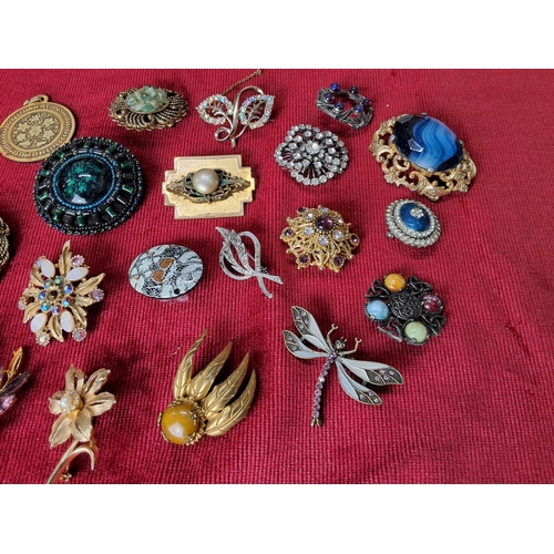 99 - A collection of vintage costume jewellery brooches & pendants.