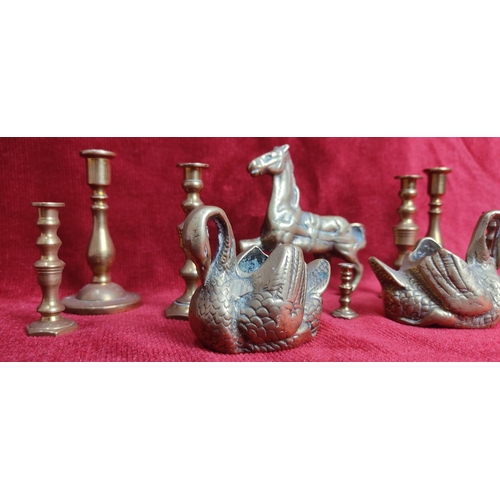 127 - A collection of brassware to include candlesticks, swan planters & more.