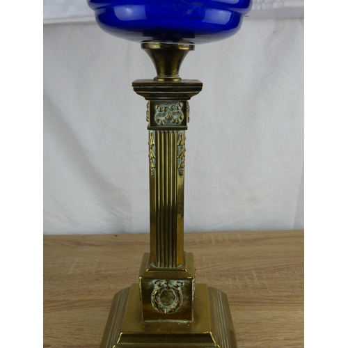 228 - Victorian brass oil lamp with ornate column base and cobalt blue glass font, featuring an etched gla... 