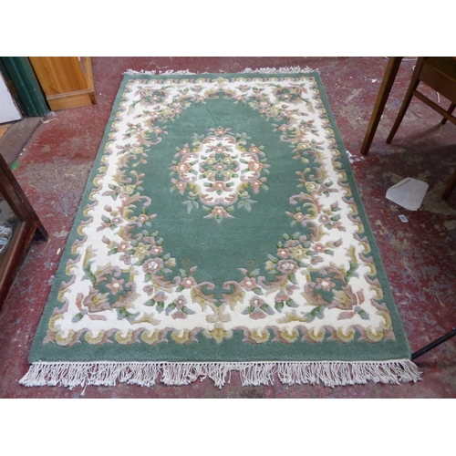 446 - A Super Ganges green patterned wool rug, measuring 4' x 6'.