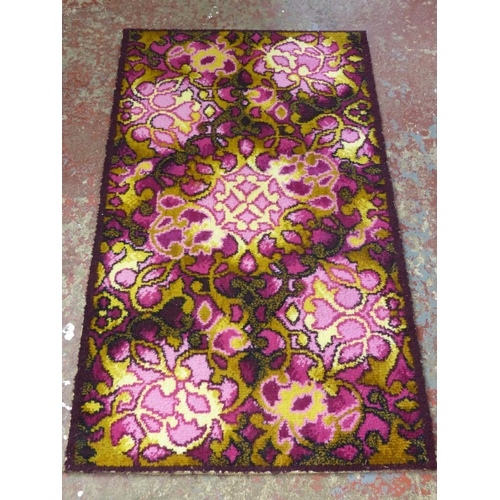 447 - A vintage patterned floor rug. 125cm x 70cm.