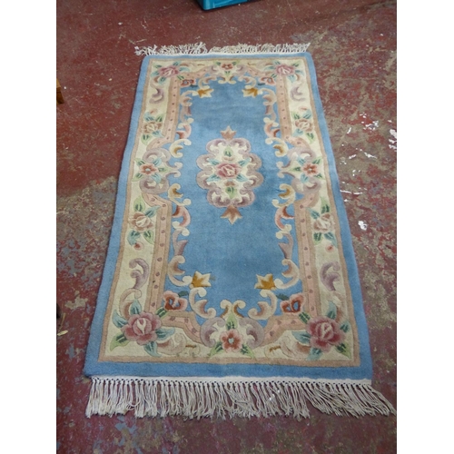 448 - A 'Lotus' blue patterned wool rug, measuring 5' x 2'6