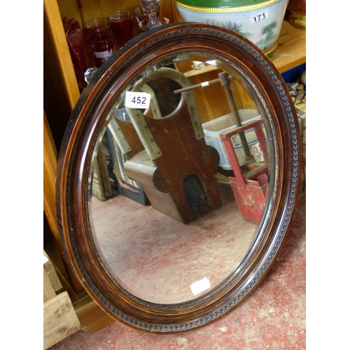 452 - A wooden framed oval wall mirror, measuring  23