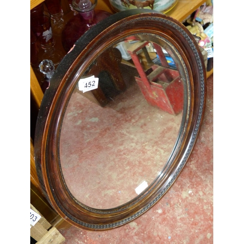 452 - A wooden framed oval wall mirror, measuring  23