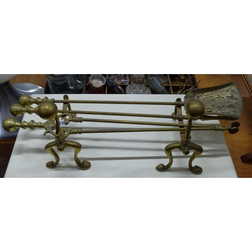 468 - A stunning antique brass fireside companion set, complete with fire dogs.