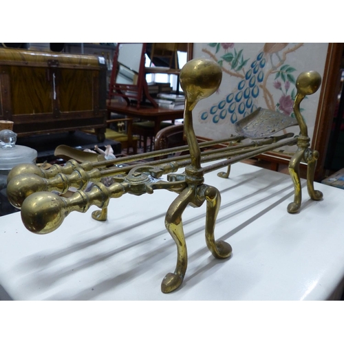 468 - A stunning antique brass fireside companion set, complete with fire dogs.