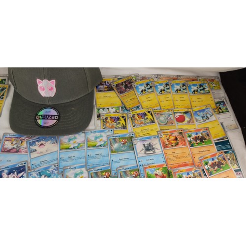 208 - A collection of Paldela Evolved Pokemon cards and a Pokemon Jiggly Puff cap with tags.