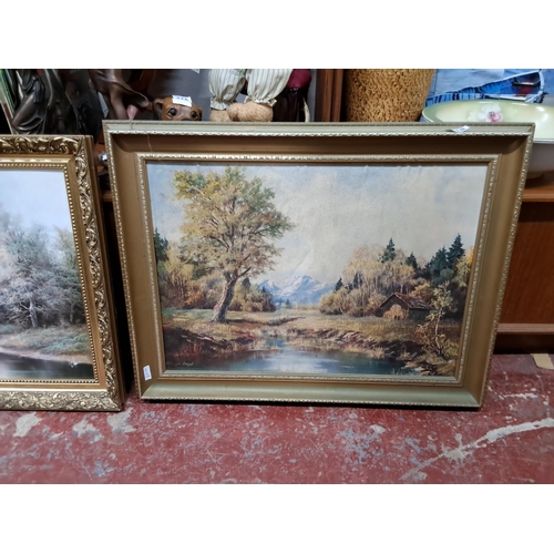 318 - Two large framed prints of rural forest scenes.