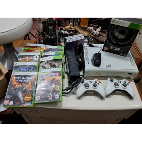 362 - An Xbox 360, two controllers and an assortment of games.