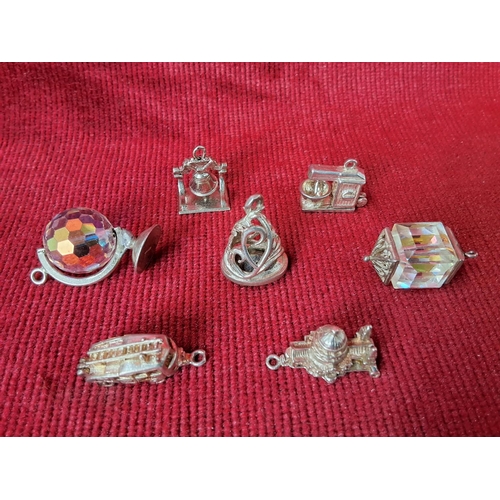 82 - A collection of 7 sterling silver and metal charms.