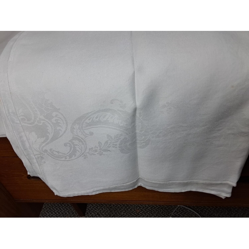 103 - A large assortment of vintage Irish linens including four Damask table cloths, large cover with lace... 