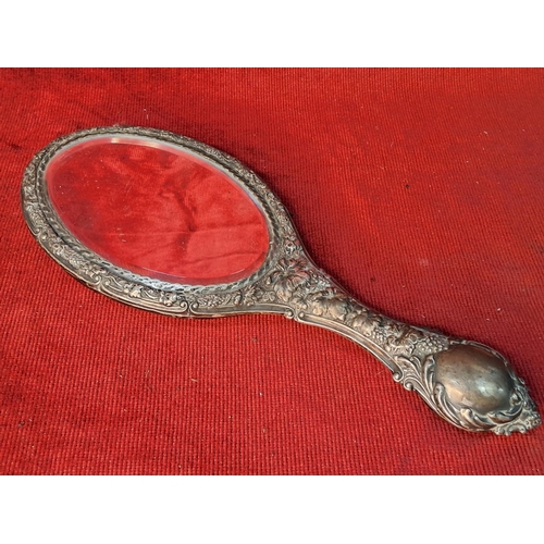 47 - An antique silver plated hand mirror. Measuring 26cm.