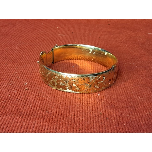 64 - A 9ct gold metal core bangle.