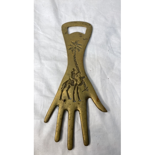 659 - A large bottle opener in the shape of a hand.