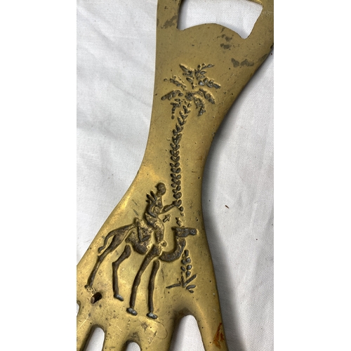 659 - A large bottle opener in the shape of a hand.