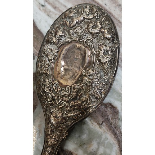 47 - An antique silver plated hand mirror. Measuring 26cm.