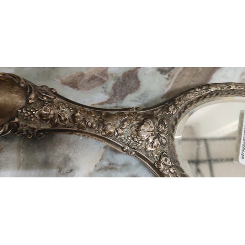 47 - An antique silver plated hand mirror. Measuring 26cm.