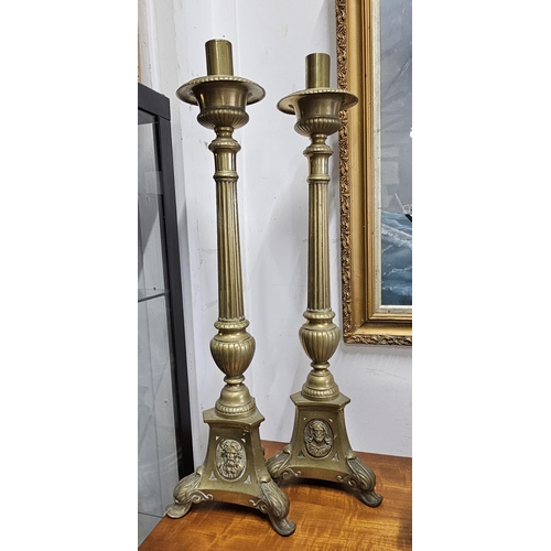 84 - A stunning pair of large antique ecclesiastical brass candlesticks, each measuring 60cm.