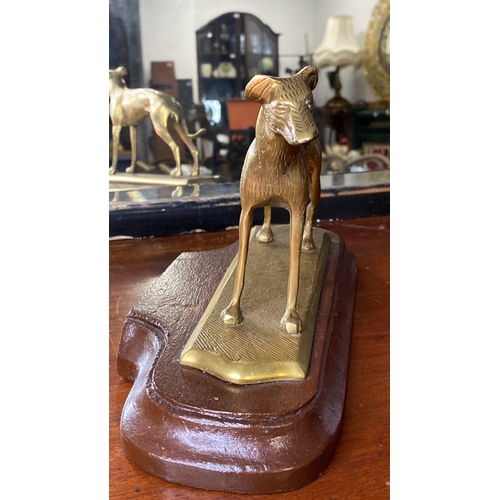 25 - A vintage brass greyhound mounted on a wooden plinth.