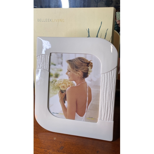 28 - A large boxed Belleek photograph frame, measuring 8