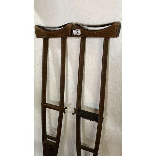 73 - A pair of antique wooden crutches.