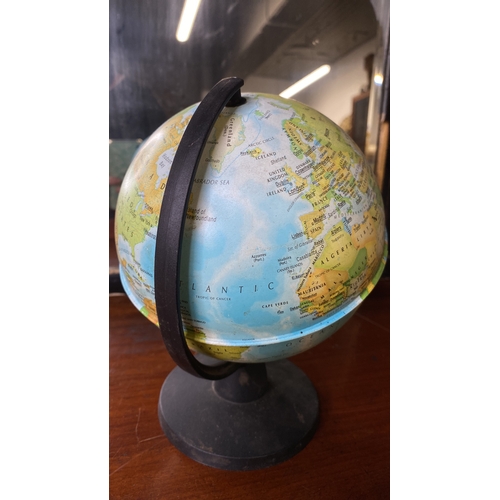 80 - A vintage desktop globe, featuring a detailed map on a black base.