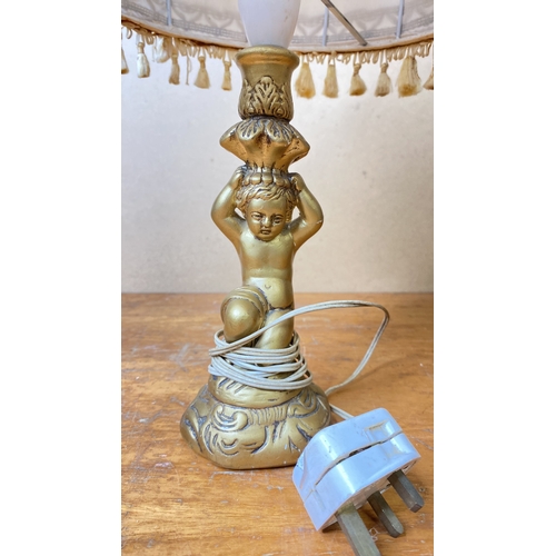 217 - A gilt cherub based table lamp and shade.