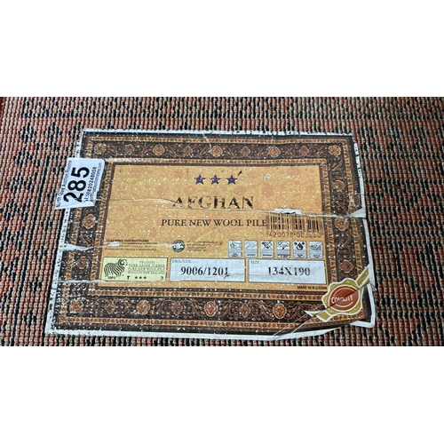 285 - An Afghan wool rug, measuring 134 x 190.