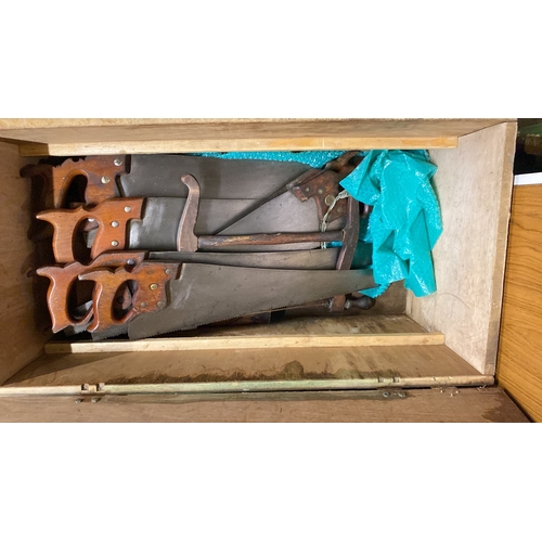 324 - Wooden tool chest containing assorted vintage hand tools, including various saws with wood handles, ... 