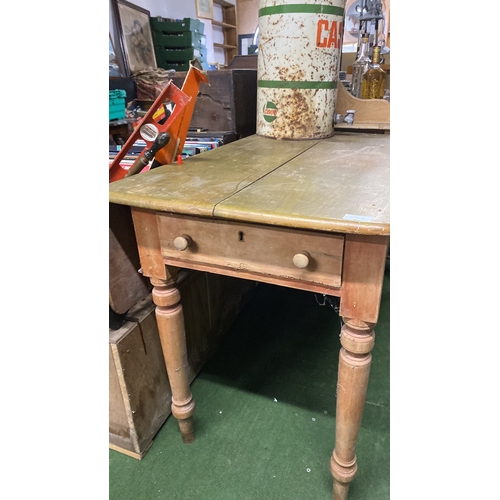 334 - A pine kitchen table, drop leaf at one side and an end drawer.