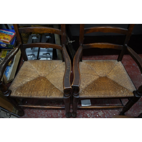 110 - A pair of oak framed ladder back armchairs