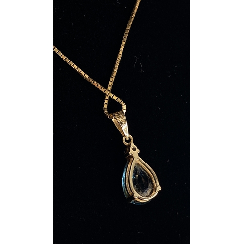 186 - A 14ct gold London blue topaz and diamond pendant on a 18