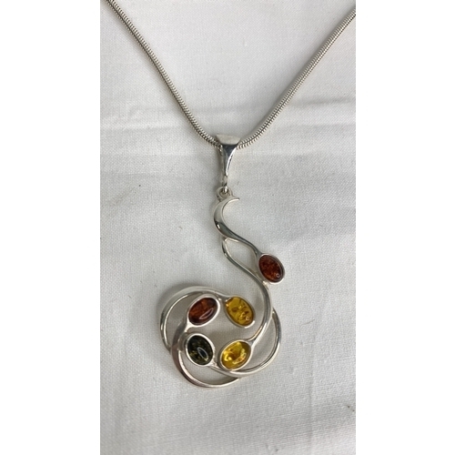 144 - A Sterling silver chain and amber pendant.