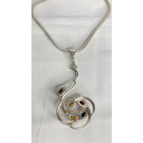 144 - A Sterling silver chain and amber pendant.