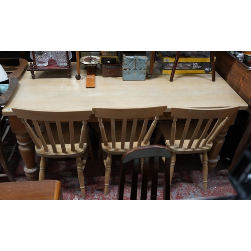 255 - A large pine kitchen table and a set of three pine kitchen chairs.