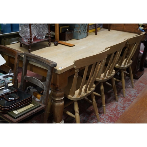 255 - A large pine kitchen table and a set of three pine kitchen chairs.