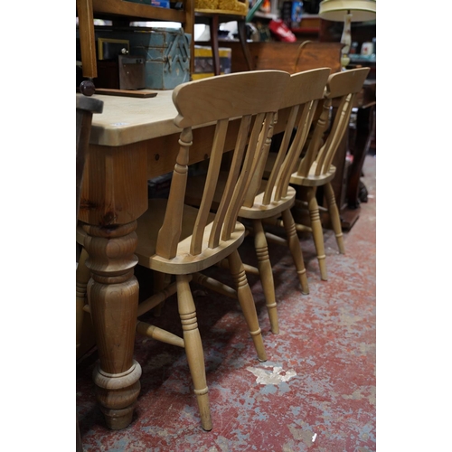 255 - A large pine kitchen table and a set of three pine kitchen chairs.