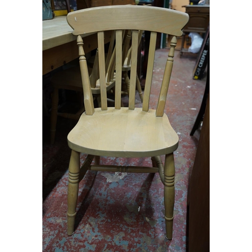 255 - A large pine kitchen table and a set of three pine kitchen chairs.