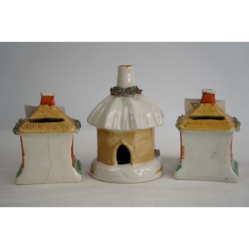 307 - Two Staffordshire pottery money boxes and another in the style of houses.