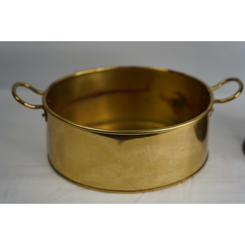 333 - A two handled brass pan and a vintage Period Pewter wine holder number 692.