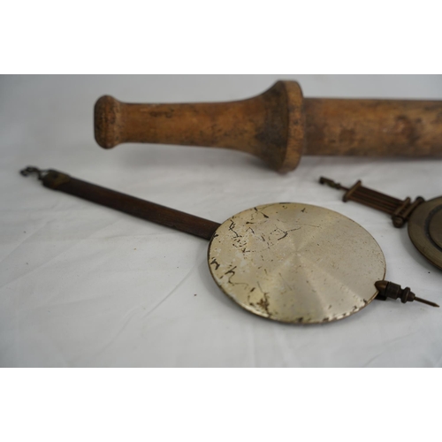 345 - A vintage wooden plunger and two clock pendulums.