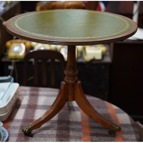 371 - An occasional leather topped table on centre pedestal with brass claw feet.