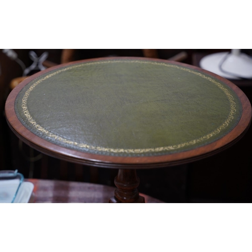 371 - An occasional leather topped table on centre pedestal with brass claw feet.