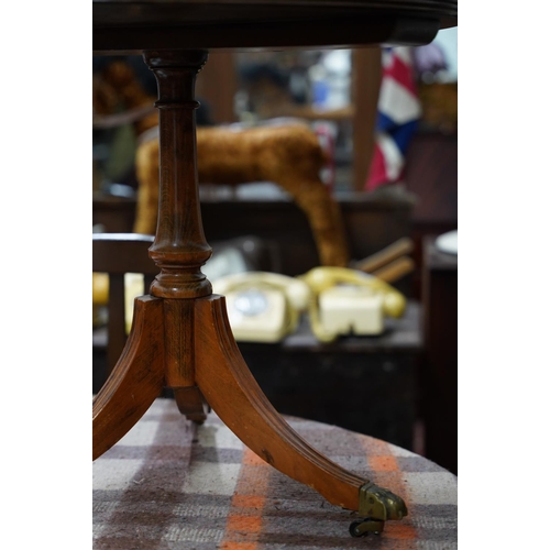 371 - An occasional leather topped table on centre pedestal with brass claw feet.