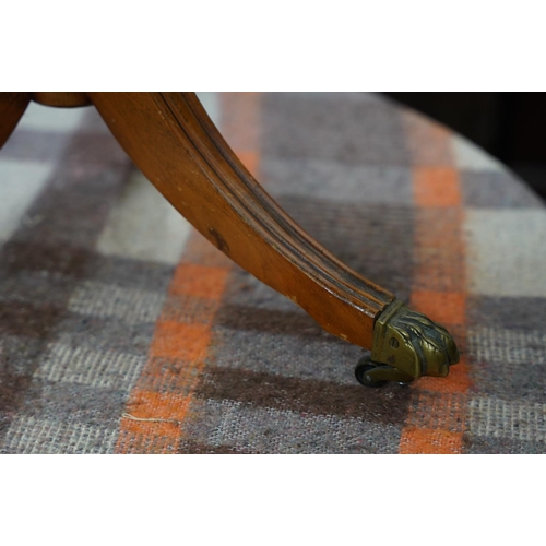 371 - An occasional leather topped table on centre pedestal with brass claw feet.