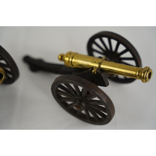 31 - A pair of antique cast metal and brass table top cannons.