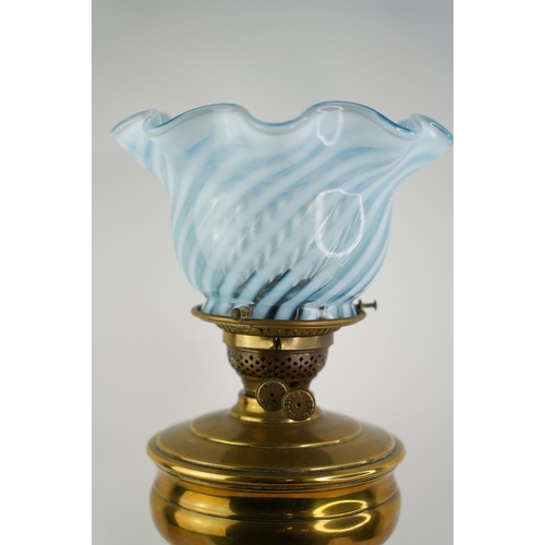 161 - An antique brass font oil lamp with blue striped patterned glass shade.