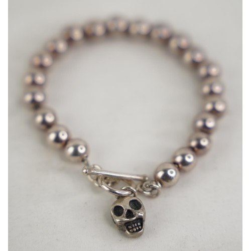 310 - A silver plated beaded and skull bracelet.