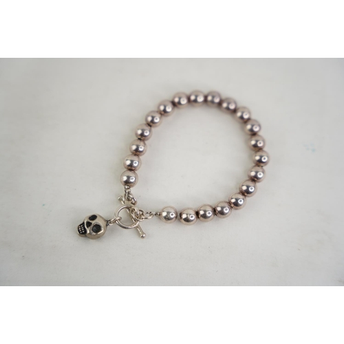 310 - A silver plated beaded and skull bracelet.